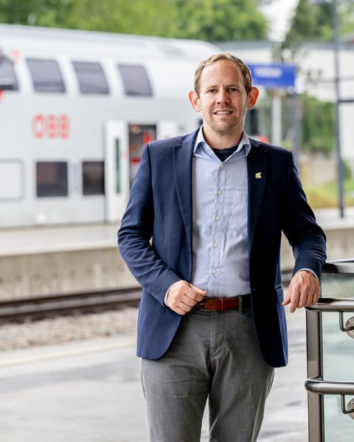 Georg Ecker steht am Bahnsteig vor einem Zug der &Ouml;BB